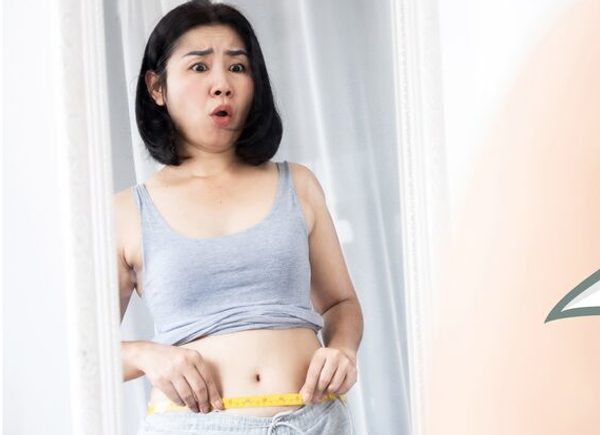 ぽっこりお腹を気にして測る女性